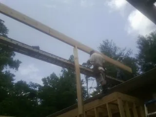 Carpenter setting a ridge beam over a new addition frame — Ice Dam Removal by Roofing Brothers in Walpole
