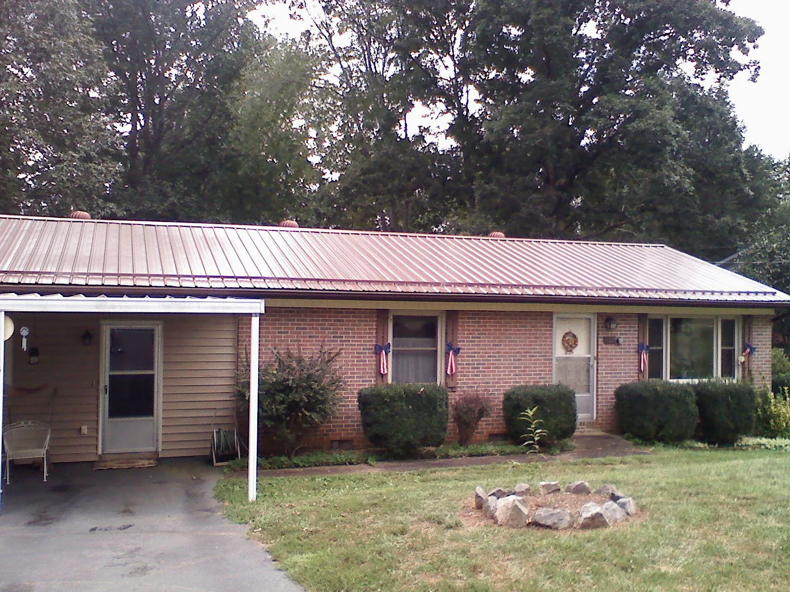 Bronze metal roof and carport on a brick ranch home — Roof Repair work by our crew in Walpole